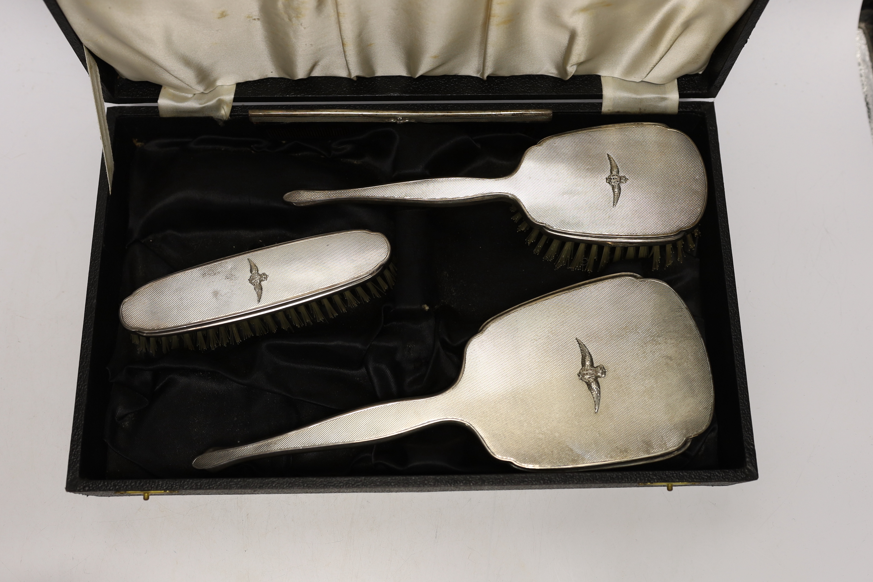 An Elizabeth II cased silver mounted three piece mirror and brush set, with RAF wings applique, twelve sterling spoons and a silver mounted glass preserve jar.